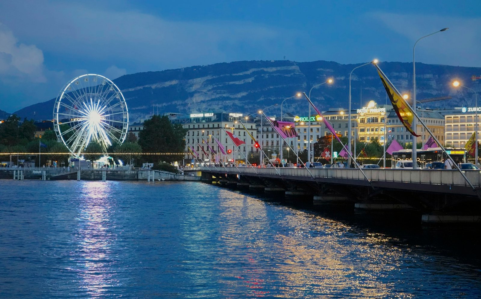 The Geneva waterfront and Ferris wheel lit up at dusk